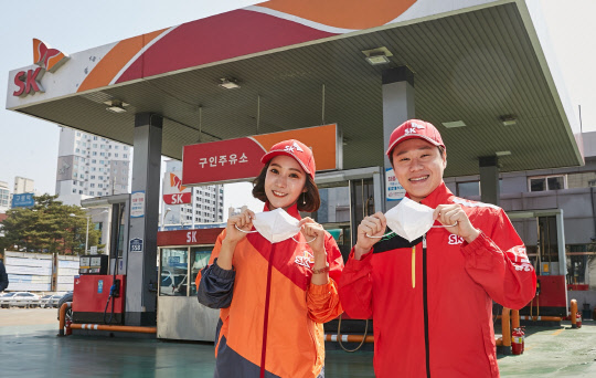 SK에너지는 노후 유조차량 교체지원 자금을 확대하고 주유소 직원 전원에게 미세먼지 차단 마스크를 지급했다고 31일 밝혔다. 서울 구로구 소재 구인주유소에서 주유원들이 지급 받은 미세먼지 차단 마스크를 들어 보이고 있다. SK에너지 제공